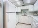 Well-lit kitchen with white appliances and marble countertops at 1415 Ocean Shore Blvd # 309, Ormond Beach, FL 32176