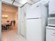 Galley kitchen with a white refrigerator and view to the dining area at 1415 Ocean Shore Blvd # 309, Ormond Beach, FL 32176
