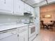 Bright kitchen featuring white cabinets, appliances, and marble countertops at 1415 Ocean Shore Blvd # 309, Ormond Beach, FL 32176