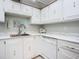 Bright and organized kitchen sink area featuring white cabinets at 1415 Ocean Shore Blvd # 309, Ormond Beach, FL 32176