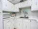 Kitchen sink area with white cabinets and marble countertops at 1415 Ocean Shore Blvd # 309, Ormond Beach, FL 32176