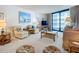 Bright living room with comfortable seating, a glass coffee table, and beach-themed decor at 1415 Ocean Shore Blvd # 309, Ormond Beach, FL 32176
