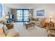 Well-lit living room with comfortable seating, a glass coffee table, and a balcony at 1415 Ocean Shore Blvd # 309, Ormond Beach, FL 32176