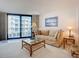 Cozy living room features a balcony, comfortable seating, and a glass coffee table at 1415 Ocean Shore Blvd # 309, Ormond Beach, FL 32176