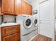 Bright laundry room, washer, dryer, cabinets, sink, and exterior access at 32200 Ponderosa Ave, Deland, FL 32720