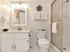 Cozy bathroom featuring a vanity sink, toilet, and glass-enclosed shower with nautical themed decor at 1513 Ocean Shore Blvd # 7B, Ormond Beach, FL 32176