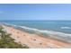 Expansive beach view from a high-rise building, showcasing the coastline, ocean, and beachside amenities at 1513 Ocean Shore Blvd # 7B, Ormond Beach, FL 32176