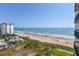 Expansive beach view from a high-rise building, showcasing the coastline, ocean, and beachside amenities at 1513 Ocean Shore Blvd # 7B, Ormond Beach, FL 32176