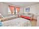 Bright bedroom with two twin beds, a wicker daybed, and natural light from the large windows at 1513 Ocean Shore Blvd # 7B, Ormond Beach, FL 32176