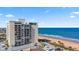 Lovely exterior view of a beachfront high rise building, beach and the ocean beyond on a bright sunny day at 1513 Ocean Shore Blvd # 7B, Ormond Beach, FL 32176