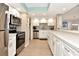 Modern kitchen with stainless steel appliances, white cabinetry, and mosaic backsplash at 1513 Ocean Shore Blvd # 7B, Ormond Beach, FL 32176