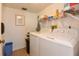 Functional laundry room with a washer, dryer, shelving, and ample space for storage at 1513 Ocean Shore Blvd # 7B, Ormond Beach, FL 32176
