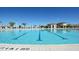 The community pool features clear blue water, lounge seating, and palm trees under a bright blue sky at 505 Ocean Course Ave # 505, Davenport, FL 33896