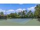 Exterior shot of a well-maintained tennis court with new surfacing, tall fencing, and shaded spectator benches at 111 Asterbrooke Dr, Deland, FL 32724