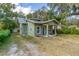 House exterior showcasing a green stucco home with a walkway and landscaping at 112 S Chandler Ave, Deland, FL 32724