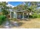 Green stucco house exterior with a walkway, landscaping, and a detached garage at 112 S Chandler Ave, Deland, FL 32724