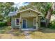 Green house exterior with a covered porch, brick walkway, and landscaping at 112 S Chandler Ave, Deland, FL 32724