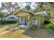 Charming green bungalow featuring a covered porch and beautifully landscaped front yard at 112 S Chandler Ave, Deland, FL 32724