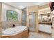 Bright bathroom featuring a walk-in shower, jetted tub and travertine tile at 3428 Longleaf Rd, Ormond Beach, FL 32174