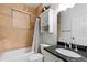 Well-lit bathroom with granite countertop vanity, tile walls, and bathtub with shower at 3428 Longleaf Rd, Ormond Beach, FL 32174