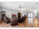 Open-concept living room with leather furniture, tiled floors, and statement lighting at 3428 Longleaf Rd, Ormond Beach, FL 32174