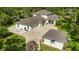 Rear exterior view featuring a lush green yard, detached garage, and expansive driveway at 3428 Longleaf Rd, Ormond Beach, FL 32174