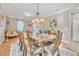 Bright dining room features a large wooden table with seating for eight and a stylish chandelier at 450 W Delaware Ave, Lake Helen, FL 32744