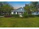 Attractive light blue house with a porch, landscaping, and American flag at 450 W Delaware Ave, Lake Helen, FL 32744