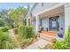 Inviting front porch with brick flooring, potted plants, and seating at 450 W Delaware Ave, Lake Helen, FL 32744