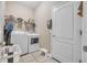 Clean laundry room with washer, dryer, shelving, and a small stool at 450 W Delaware Ave, Lake Helen, FL 32744