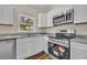 This kitchen has granite countertops, stainless steel appliances, and white cabinets at 210 E Baxter St, De Leon Springs, FL 32130