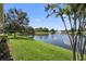 A lush green lawn borders a scenic pond featuring a fountain in a serene backyard setting at 309 Chesham St, Ormond Beach, FL 32174