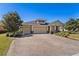 Charming home with a three-car garage and a well-maintained driveway, surrounded by lush landscaping at 309 Chesham St, Ormond Beach, FL 32174