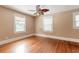 Bedroom with hardwood floors, ceiling fan, and natural light from the three windows at 724 N Oleander Ave, Daytona Beach, FL 32118