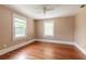 Bedroom with hardwood floors, ceiling fan, and natural light from the two windows at 724 N Oleander Ave, Daytona Beach, FL 32118