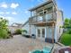 Exterior view of a home with a private balcony overlooking a paver patio, string lights, and landscaping at 4011 S Peninsula Dr, Port Orange, FL 32127