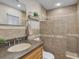 Bathroom features a granite countertop, tile shower, and modern fixtures at 4011 S Peninsula Dr, Port Orange, FL 32127