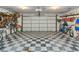 Clean and organized garage featuring a checkered floor, storage shelves, and a variety of tools and equipment at 4011 S Peninsula Dr, Port Orange, FL 32127