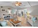 Spacious living room with light wood floors, a ceiling fan, and views into the kitchen and dining area at 4011 S Peninsula Dr, Port Orange, FL 32127