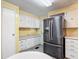 Bright kitchen with black stainless steel refrigerator and plenty of cabinets for storage at 824 Silver Oak Ave, The Villages, FL 32159