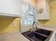A close up of the black undermount kitchen sink, under cabinet window, and faucet at 824 Silver Oak Ave, The Villages, FL 32159