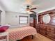 Cozy main bedroom with hardwood floors, ceiling fan and a large dresser at 824 Silver Oak Ave, The Villages, FL 32159