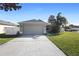 House exterior showcasing a driveway and attached garage at 3435 Arabesque Dr, Deland, FL 32724