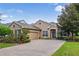 House exterior featuring a brick driveway and well-manicured lawn at 210 Brookgreen Way, Deland, FL 32724