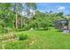 Expansive backyard featuring lush green grass, garden beds, and a screened-in porch, creating a serene outdoor living space at 317 Nowell Loop, Deland, FL 32724