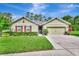 Charming single-story home featuring a well-manicured lawn and a two-car garage at 317 Nowell Loop, Deland, FL 32724