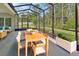 Enclosed patio featuring an outdoor dining area and lounge space surrounded by lush greenery at 317 Nowell Loop, Deland, FL 32724