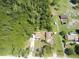 Aerial view of the property showcasing the home, surrounding land, and nearby wooded areas, with other buildings at 4205 Quail Ranch Rd, New Smyrna Beach, FL 32168