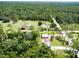 Aerial view of the property showcasing the home, expansive land, trees, and the surrounding neighborhood at 4205 Quail Ranch Rd, New Smyrna Beach, FL 32168