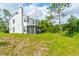 Expansive backyard with lush green grass, a screened-in porch, and mature trees, perfect for outdoor enjoyment at 4205 Quail Ranch Rd, New Smyrna Beach, FL 32168